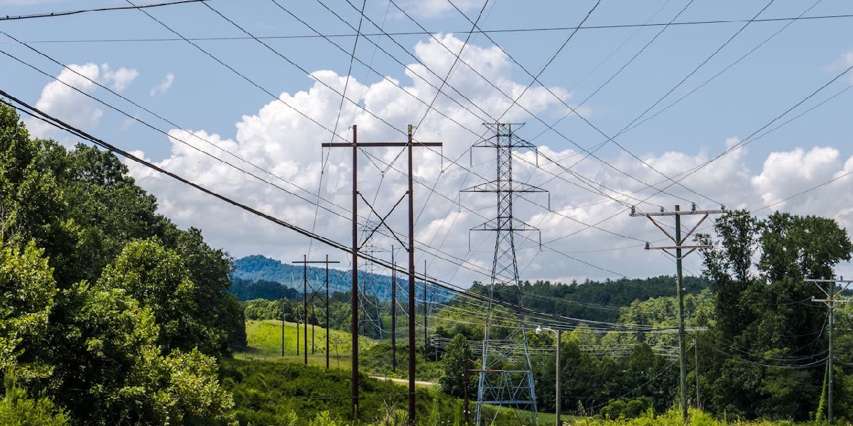 Large power lines over green pastures